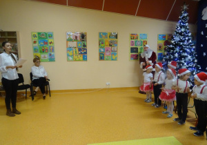Pani dyrektor Maria Królikowska przygląda się występującym dzieciom. Pani Ania Tylman śpiewa z dziećmi piosenkę.